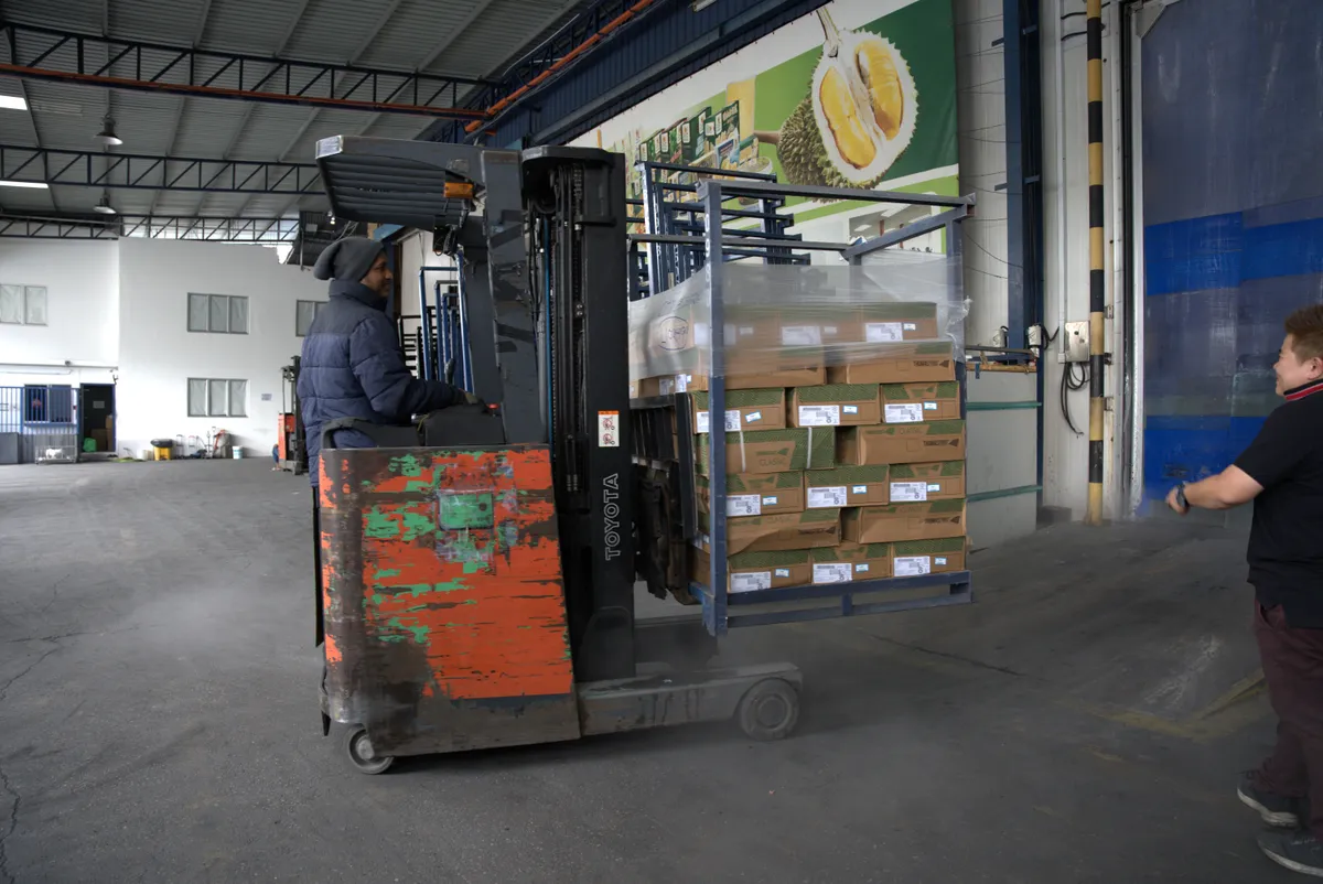 An Arctic forklift operator moving palletised stock at the Kepong cold-room loading dock